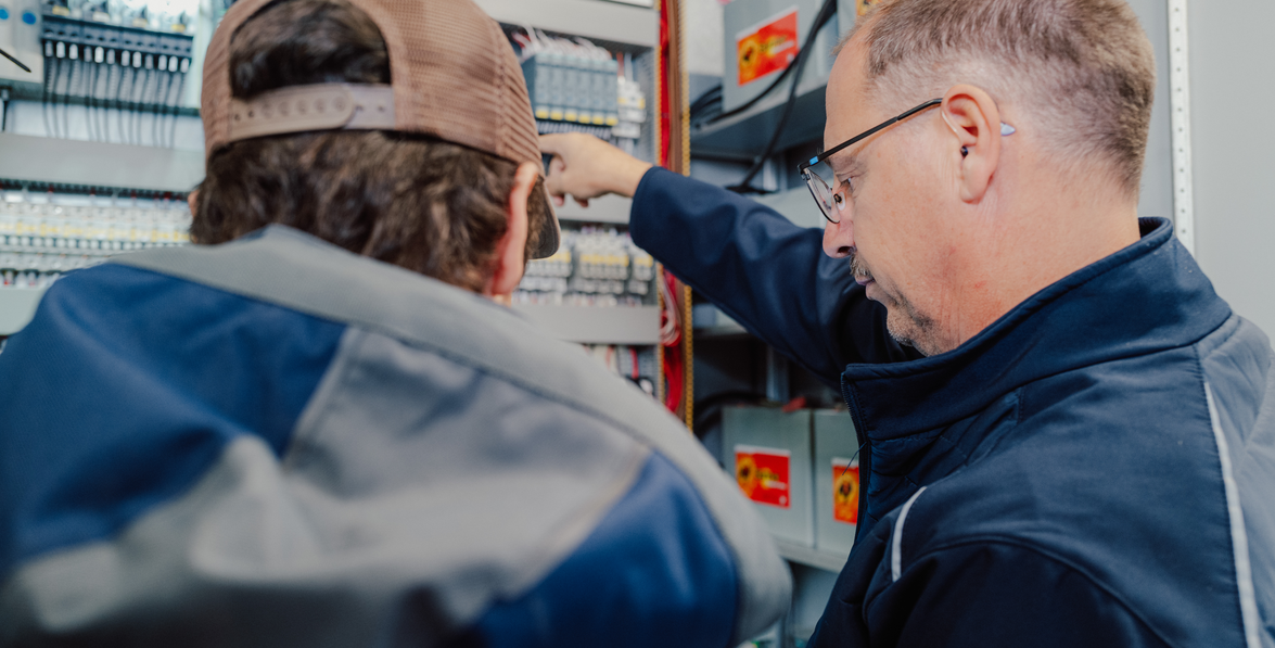 Zwei Elektriker arbeiten an einem Schaltschrank